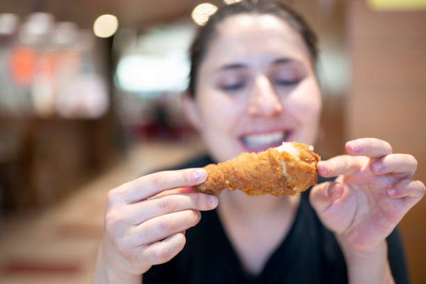 giovane donna con pollo fritto - deep fried people fried chicken foto e immagini stock