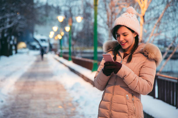 istock Woman using phone in the winter 1184835414