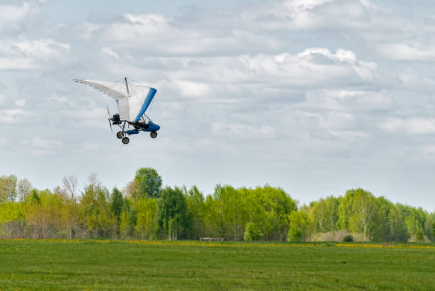 Blagoveshchenskaya, Russia - July 8, 2018: Trike, flying in the sky with two people. Extreme Entertainment travelers. A flying hang-glider with a motor in the sky. Entertainment of tourists on the sea.