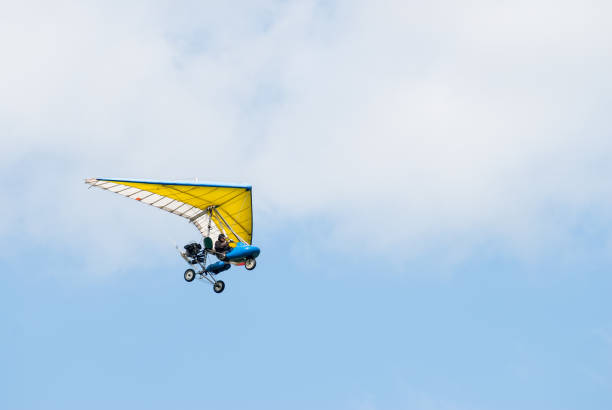 motorized hang glider in the sunset above sea - aero imagens e fotografias de stock