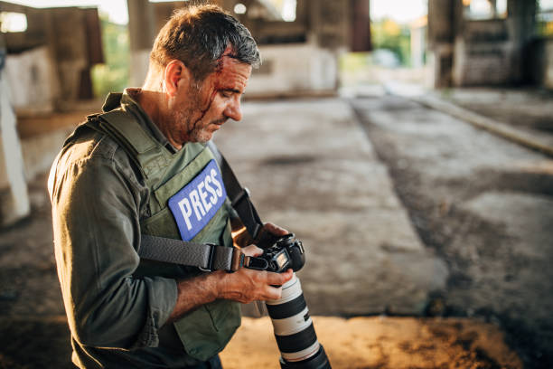 istock Wounded man war reporter with camera in war zone 1184840487
