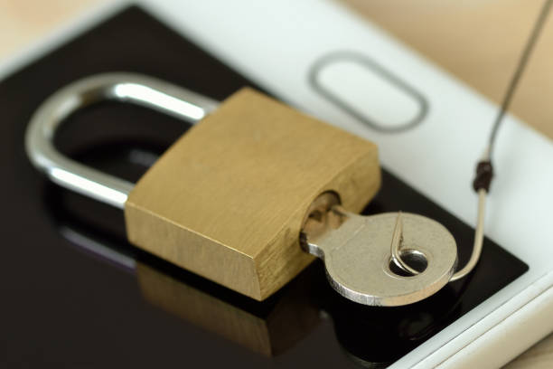 istock Padlock and key with fish hook on mobile phone - Concept of phishing and mobile security 1184843459