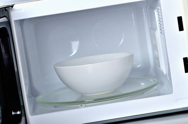 istock Interior of the microwave oven with clean empty white bowl 1184846192