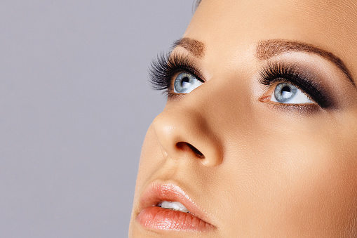Eyelash extensions, makeup, cosmetics, beauty. Close up portrait
