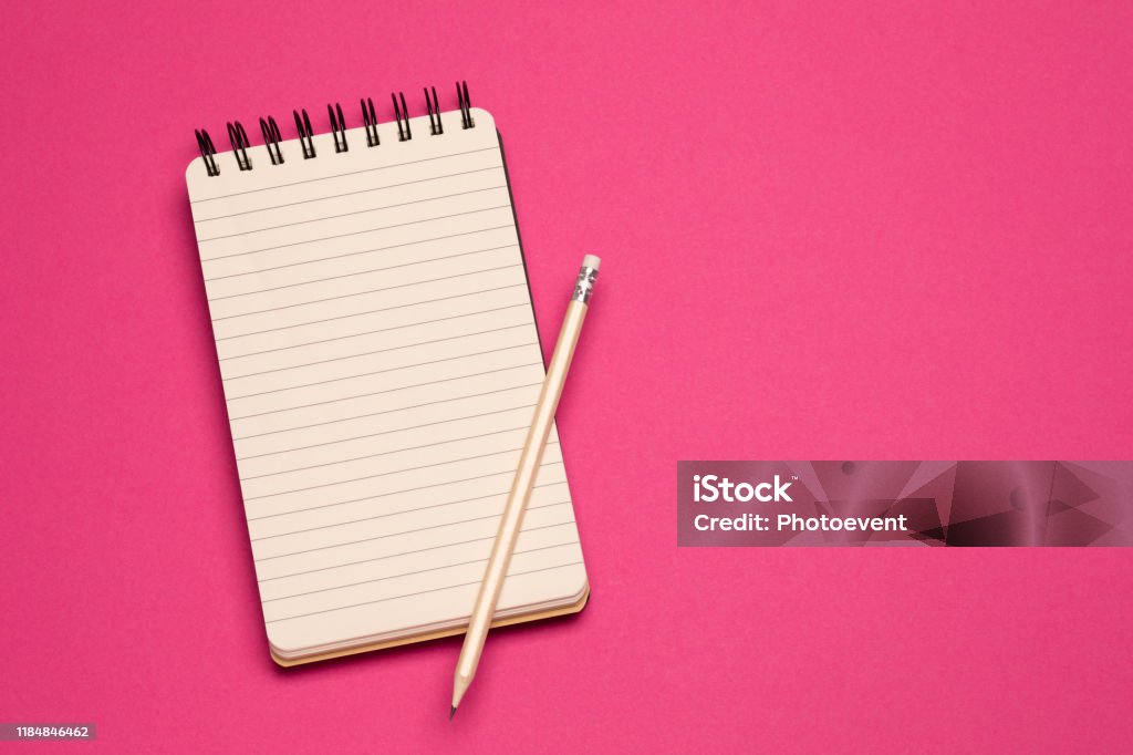 Shopping list - Concept Spiral notebook and pencil on pink background"r Note - Message Stock Photo