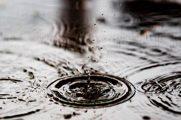 istock Splash water from rain droplets on wet ground 1184847341