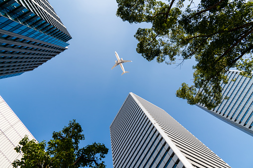 Airplane in the city flying over modern buildings. Osaka, Japan