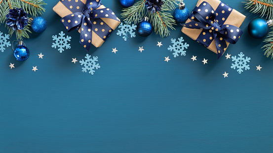Vintage borde marco de Navidad. Abeto plano tres ramas, bolas azules y copos de nieve sobre fondo azul. Vista superior, copiar espacio. Plantilla de tarjeta de felicitación de Año Nuevo, maqueta de postal de Navidad. photo
