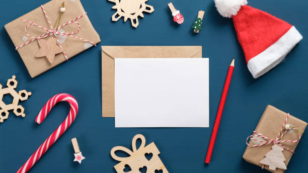 istock Vintage Christmas elements set. Flat lay retro wooden decorations, candy cane, New Year hat, gift boxes wrapped craft paper, envelope with blank white card. Top view, overhead. Winter holiday concept 1184848561