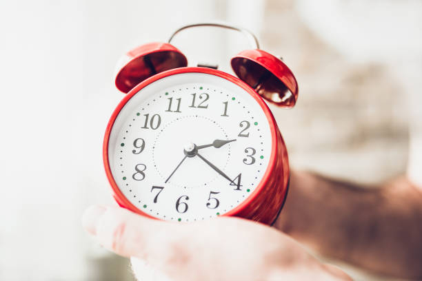 istock Caucasian man setting the alarm clock at 7 1184849688