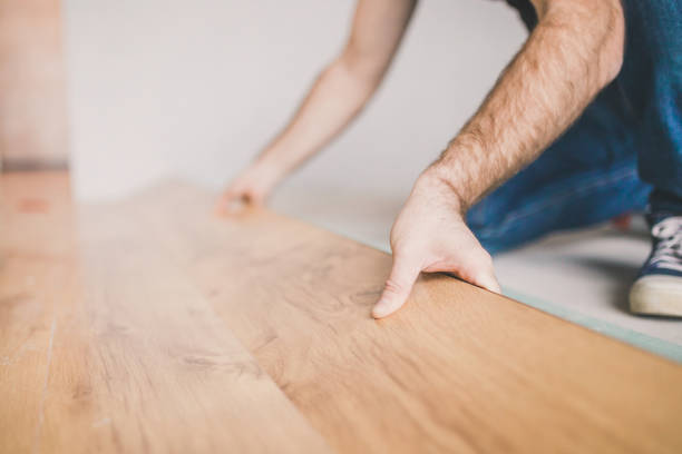 istock Adult man lays the laminate panel on the substrate 1184852623