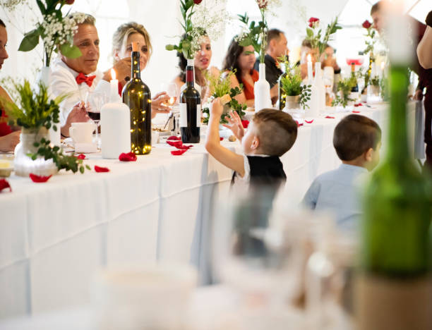 Kid stealing bread at the table of honour at wedding reception.