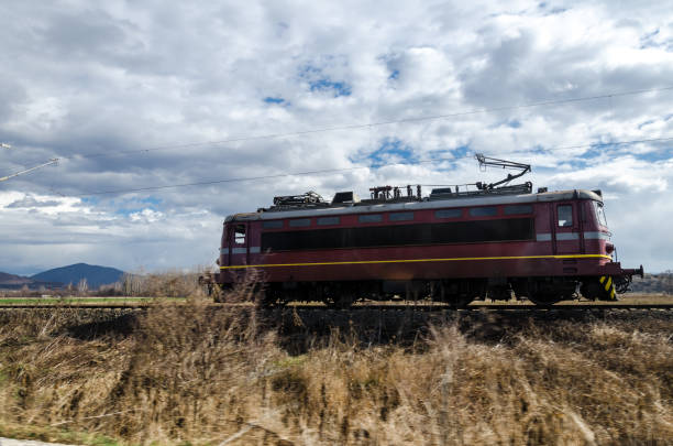 Locomotive without train composition is moving lonely under the blue cloudy sky