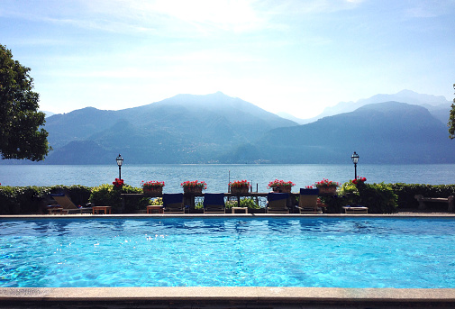 Clear blue pool in the foreground with view of Lake Como, Italy