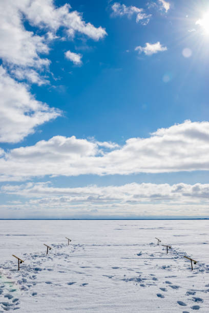 A view looking down on the tip of the ice fishing pole in the lakebed of the cold utah mountains.