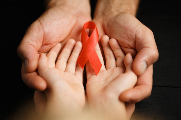 istock child with AID red ribbon on a dark background 1184865239