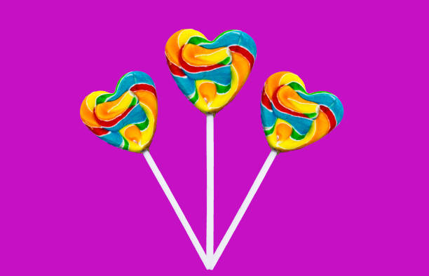 istock three colorful heart lollipops on a pink background. 1184868521