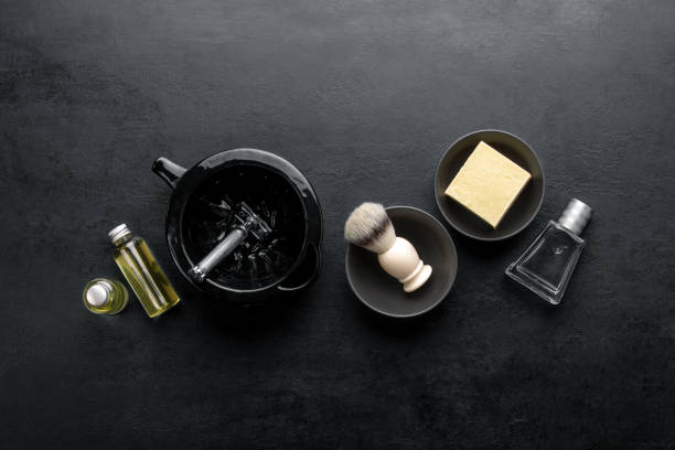 Shaving accessories set on a dark background, top down view