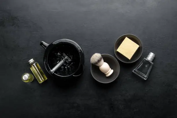 Photo of Shaving accessories set on a dark background, top down view