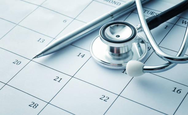 カレンダー上の聴診器とペン - healthcare and medicine calendar medical exam plan ストックフォトと画像