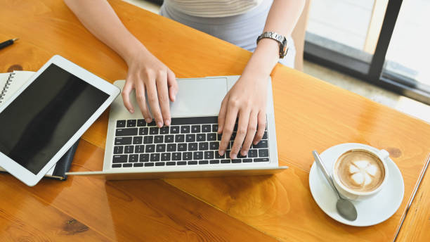 istock Above top view female using laptop computer with coffee latte. 1184873682