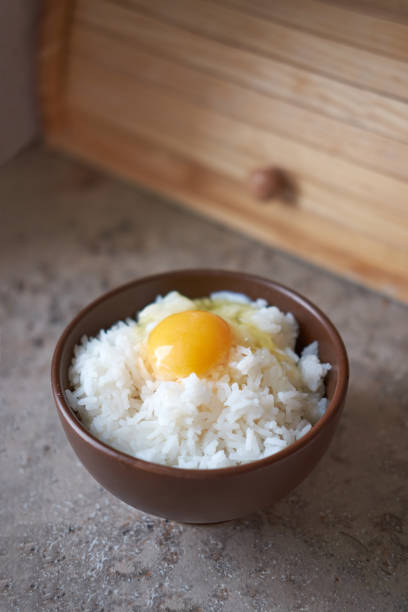 istock Tamago kake gohan with raw egg in bowl, vertical orientation 1184877479