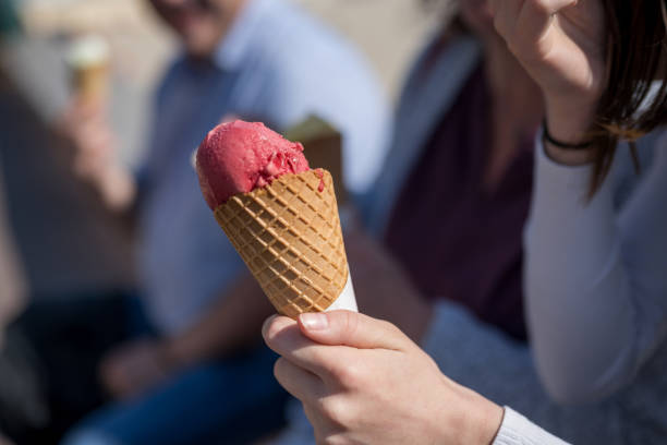 istock Woman holding raspberry ice cream in cone 1184877573