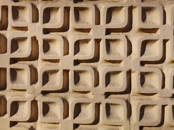 istock Details of geometric stucco work on an exterior wall. Light beige plaster pattern. Decorated wall in bright sunlight 1184879932