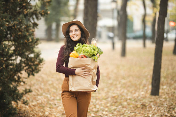 istock Woman walking with grocery bag 1184882683