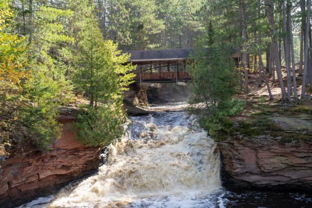 istock Amnicon Falls State Park waterfall with a covered bridge, over the Amnicon River in Northern Wisconsin 1184882769