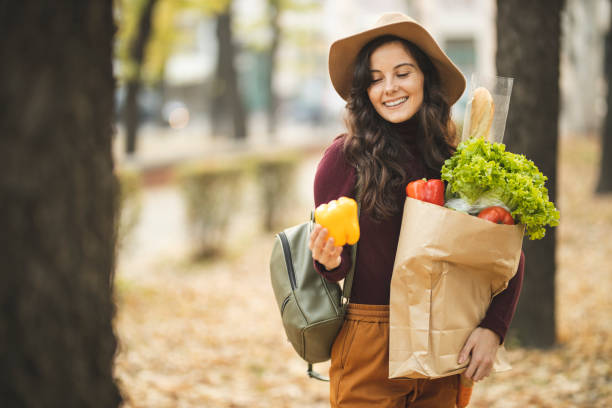 istock Schoolgirl holding grocery bag 1184882993