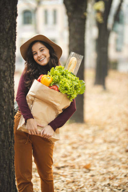 istock Woman posing with grocery bag 1184884089