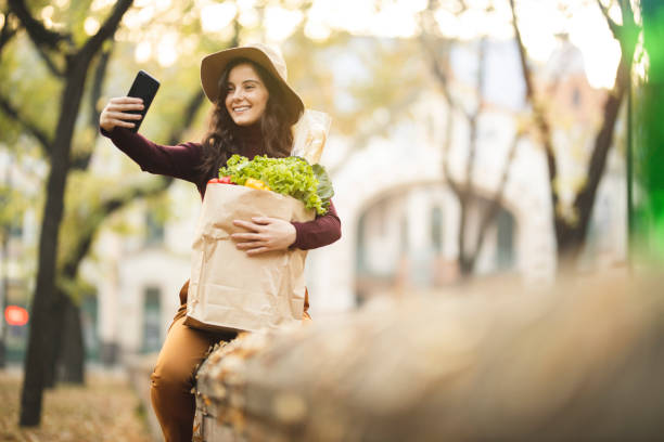 istock Woman  with grocery bag taking a selfie 1184884319