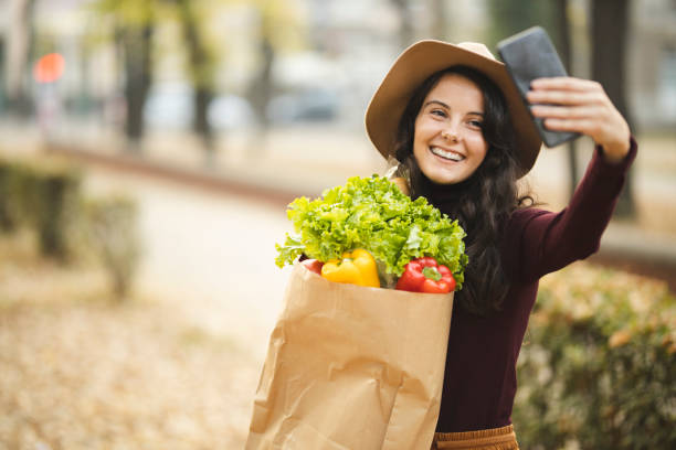 Woman with grocery bag making a selfie