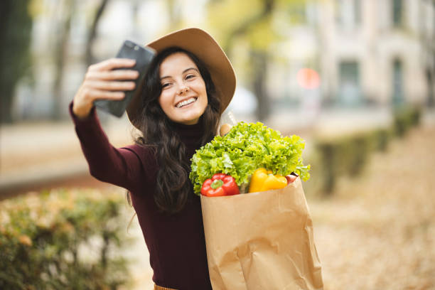 istock Woman with grocery bag taking a selfie 1184884974