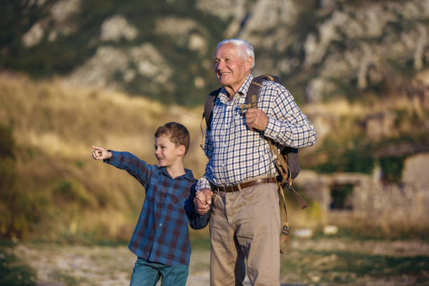 istock Grandfather and grandson holding hands while hiking 1184885087