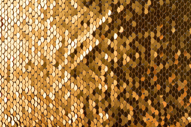 istock Sequins background. Background with shiny sequins on fabric. Abstract texture scales with gold sequins 1184888566