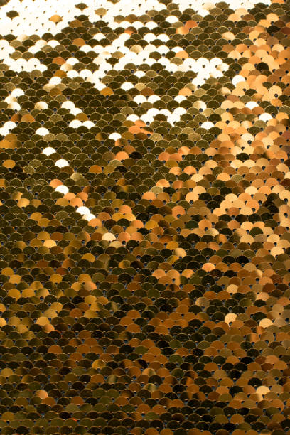 istock Sequins background. Background with shiny sequins on fabric. Abstract texture scales with gold sequins 1184888600