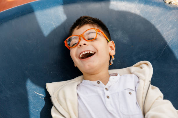 Child with multiple disabilities playing on big swing in a park.