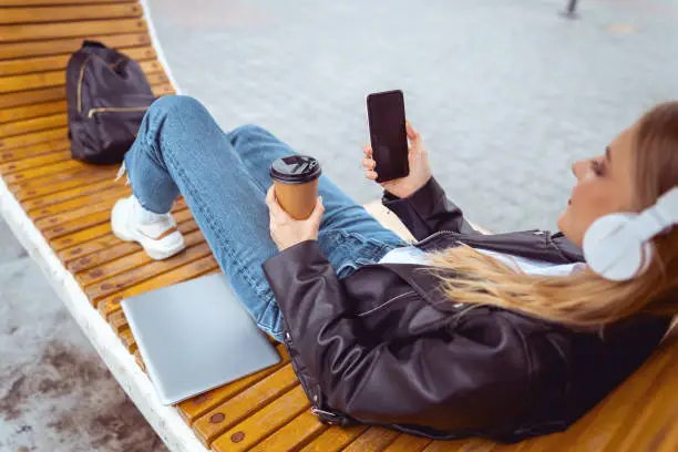 Top view of a young woman holding a blank mobile phone