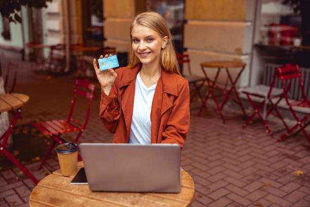 istock Female with a plastic card sitting outdoors 1184890501
