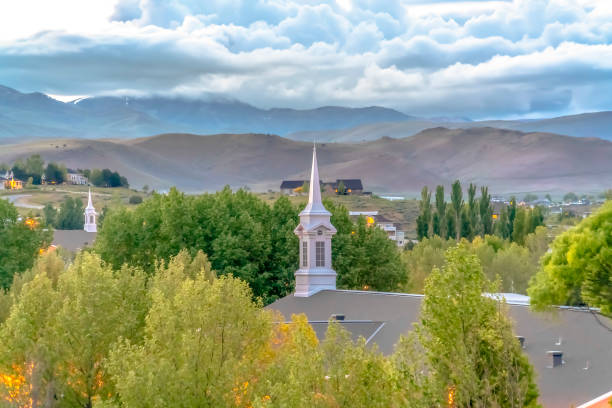 istock Looking down at a white churge steeple in the trees with mountains behind 1184890661