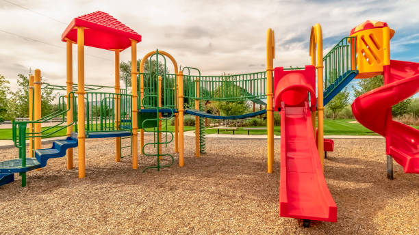 istock Panorama frame Focus on empty childrens playground at a park with red slides and climbing bars 1184893590