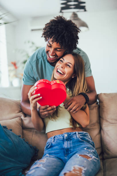 happy couple with gift box hugging at home. - valentines day red photography indoors imagens e fotografias de stock