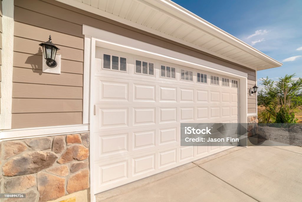 Double garage of modern home on sunny, clear day Double garage of modern home on sunny, clear day. A double garage and driveway of a modern home on a sunny, clear day. Garage Stock Photo