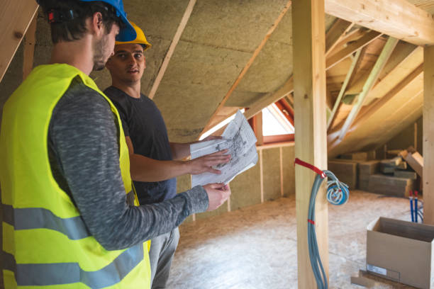 Discussing on blueprint Construction workers reviewing blueprint at construction site.Roof with mineral rockwool in wall section. House under construction with insulation glass wool on an attic floor attic photos stock pictures, royalty-free photos & images
