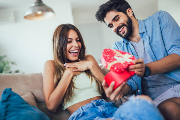 istock Handsome man is giving his girlfriend a gift box 1184897193
