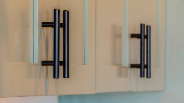istock Panorama Close up of kitchen cupboards and black handles 1184897626