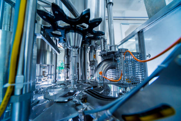 istock Automatic filling machine pours water into plastic PET bottles. Brewing production. 1184898537