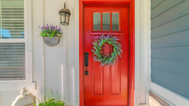 istock Panorama frame Red front door of modern home with green wreath 1184898838